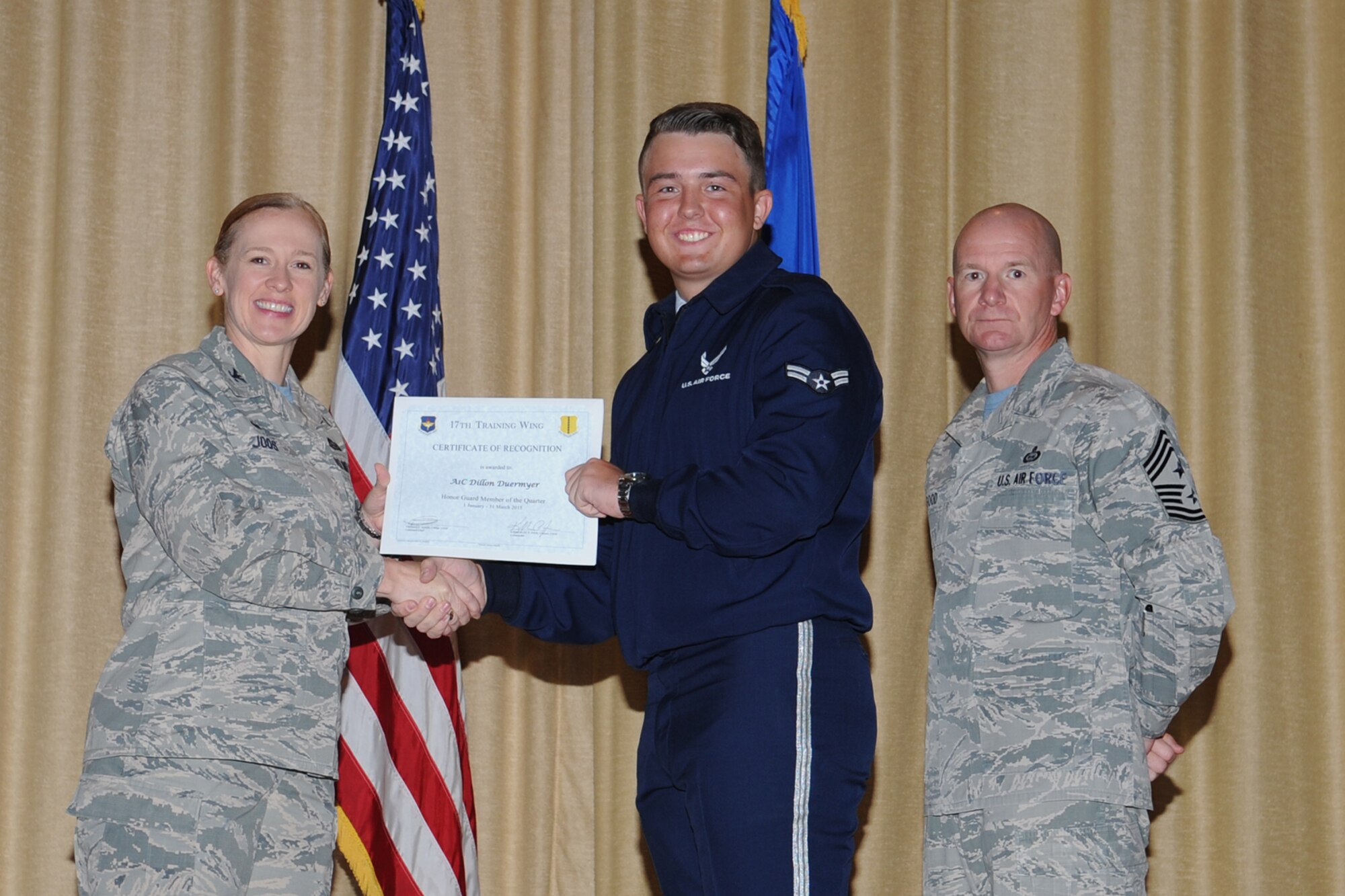 GOODFELLOW AIR FORCE BASE, Texas - Col. Kimberlee P. Joos, 17th Training Wing Commander, and Chief Master Sgt. Thomas F. Good, 17th TRW Command Chief, present the Honor Guard of the Quarter award to Airman 1st Class Dillon M. Duermyer, 17th Medical Operations Squadron, during the wing quarterly awards ceremony at the base theater April 24. (U.S. Air Force photo/ Staff Sgt. Laura R. McFarlane)