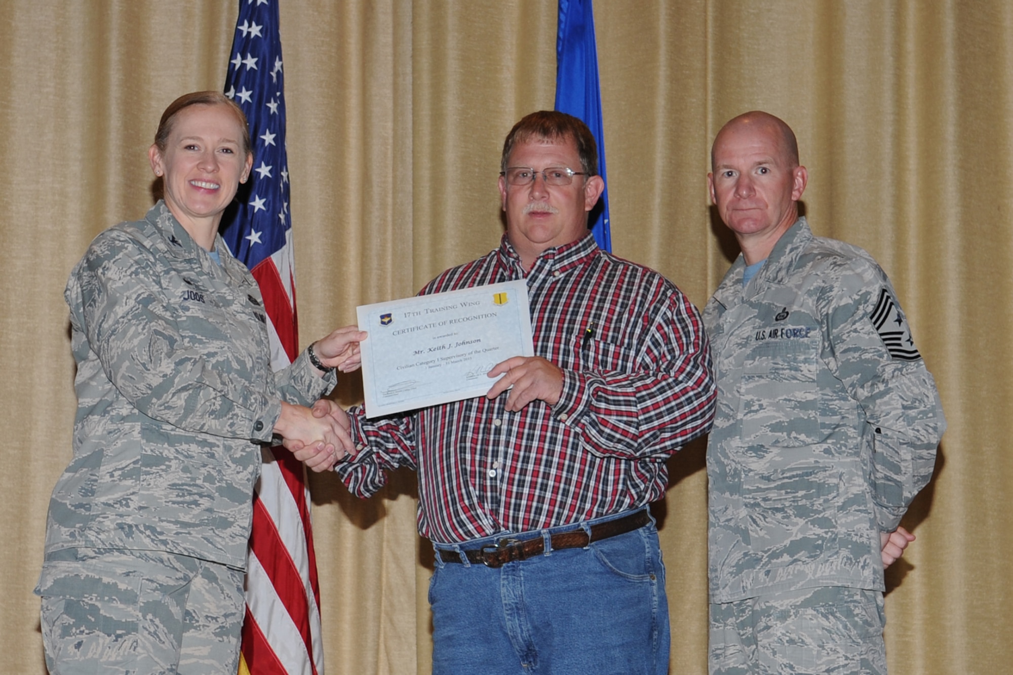 GOODFELLOW AIR FORCE BASE, Texas - Col. Kimberlee P. Joos, 17th Training Wing Commander, and Chief Master Sgt. Thomas F. Good, 17th TRW Command Chief, present the 17th Training Wing Civilian Category I Supervisory of the Quarter award to Keith J. Johnson, 17th Mission Support Group, during the wing quarterly awards ceremony at the base theater April 24. Johnson also received the Team Goodfellow Civilian Category I Supervisory of the Quarter. (U.S. Air Force photo/Staff Sgt. Laura R. McFarlane)