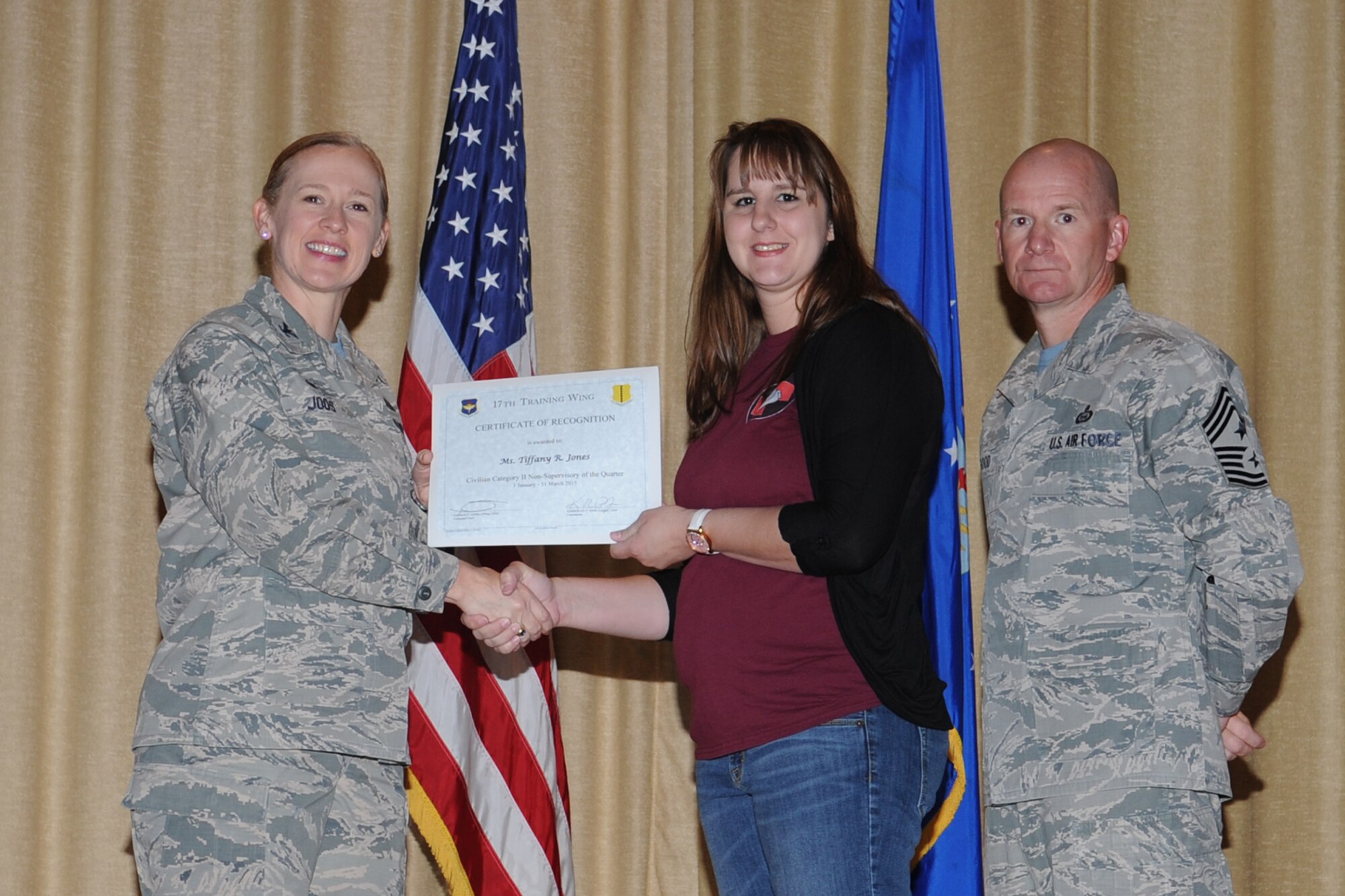 GOODFELLOW AIR FORCE BASE, Texas - Col. Kimberlee P. Joos, 17th Training Wing Commander, and Chief Master Sgt. Thomas F. Good, 17th TRW Command Chief, present the 17th Training Wing Civilian Category II Non-Supervisory of the Quarter award to Tiffany R. Jones, 17th Medical Group, during the wing quarterly awards ceremony at the base theater April 24. (U.S. Air Force photo/Staff Sgt. Laura R. McFarlane)