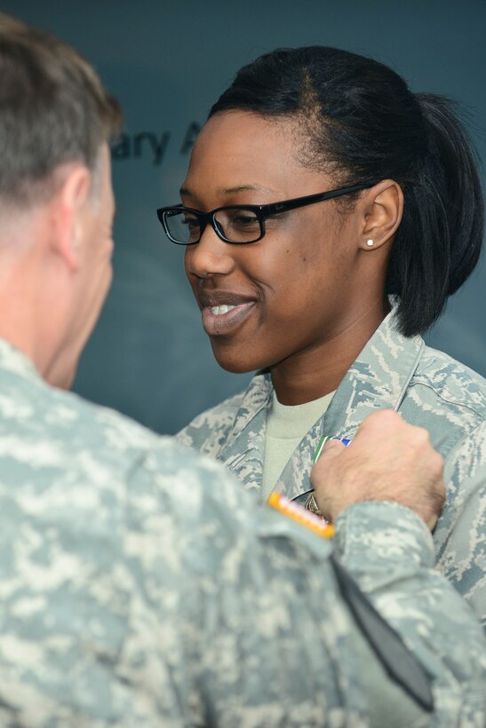 U.S. Air Force Senior Airman Latasha Brown, 633rd Force Support Squadron chef, receives an Army Achievement Medal from U.S. Army Col. William Galbraith, 733rd Mission Support Group commander at Fort Eustis, Va., April 27, 2015. The competition included individuals and teams from the five U.S. services as well as members from the United Kingdom, France and Germany. (U.S. Air Force photo by Senior Airman Kimberly Nagle/Released)