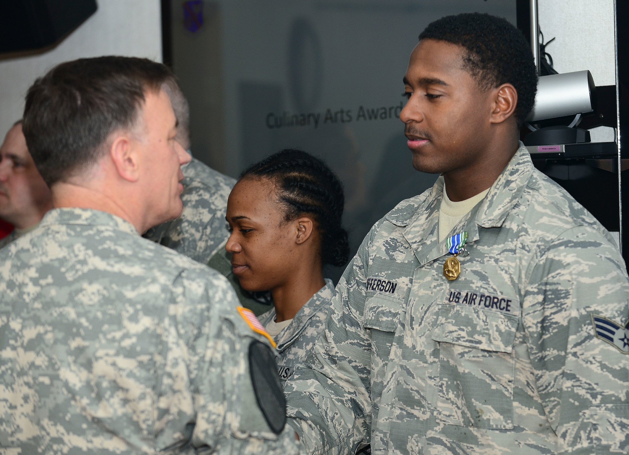 U.S. Army Col. William Galbraith, 733rd Mission Support Group commander, shakes hands with U.S. Air Force Senior Airman Damian Jefferson, 633rd Force Support Squadron chef, after awarding him an Army Achievement Medal at Fort Eustis, Va., April 27, 2015. Jefferson was part of the Joint Base Langley-Eustis Culinary Arts Team that competed in the 40th Annual Culinary Arts competition skills assessment test. (U.S. Air Force photo by Senior Airman Kimberly Nagle/Released)