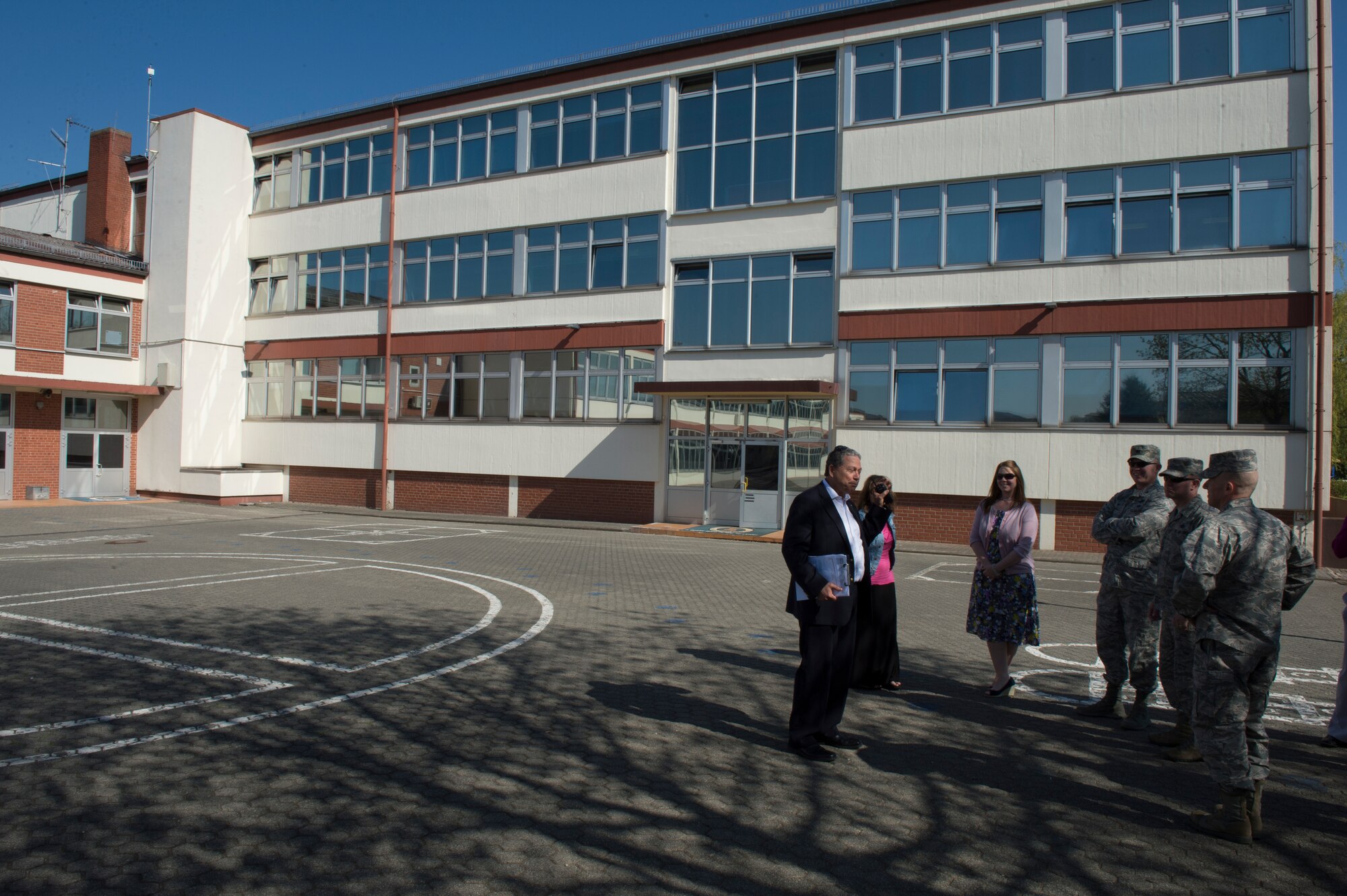 Julio Gonzalez, Bitburg Elementary School principal, welcomes U.S. Air Force Col. Joe McFall, 52nd Fighter Wing commander, and U.S. Air Force Chief Master Sgt. Brian Gates, 52nd FW command chief, to Bitburg Elementary school during a school facility tour April 23, 2015, at Bitburg Annex, Germany. Spangdahlem Elementary School students, staff and teachers will temporary relocate to Bitburg Elementary School starting its 2015/2016 school year. (U.S. Air Force photo by Staff Sgt. Christopher Ruano/Released)