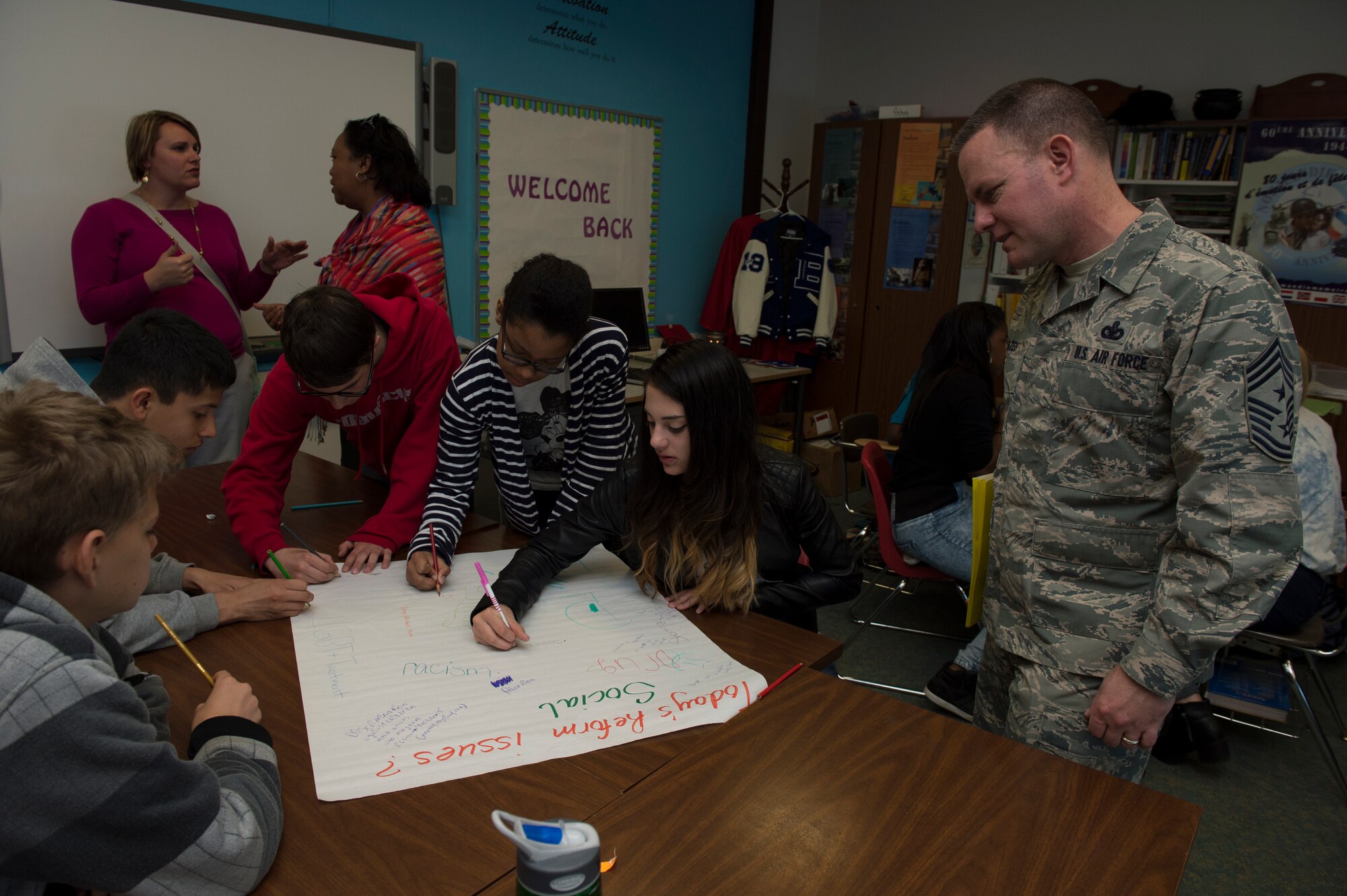 U.S. Air Force Chief Master Sgt. Brian Gates, 52nd Fighter Wing command chief, observes Bitburg Middle High School students perform a class project during a school facility tour April 23, 2015, at Bitburg Annex, Germany. The visit included lunch and presentations on school clubs and activities. (U.S. Air Force photo by Staff Sgt. Christopher Ruano/Released)