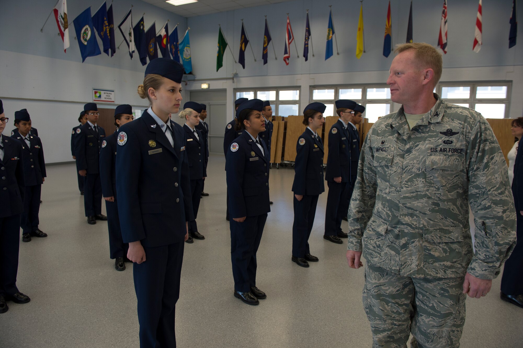 U.S. Air Force Col. Joe McFall, 52nd Fighter Wing commander, performs open ranks on Bitburg Middle High School Junior Reserve Officers' Training Corp cadets during a school facility tour April 23, 2015, at Bitburg Annex, Germany. McFall spoke with the cadets and gave a select few commander coins for their exemplarily service. (U.S. Air Force photo by Staff Sgt. Christopher Ruano/Released)