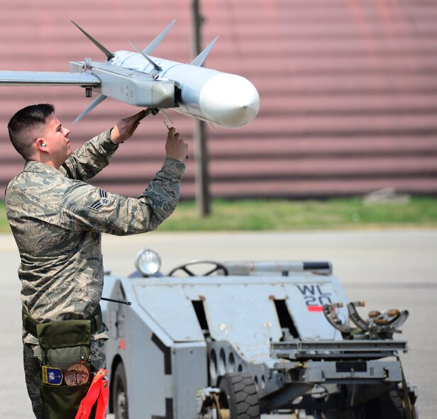 Senior Airmen Sheldon Hopka from the 36th Aircraft Maintenance Unit removes the tail fins from a Sidewinder missile in preparation for the simulated switch of training to combat load munitions on an F-16 fighter jet during the Quarterly Load competition at Osan Air Base, Republic of Korea 10 April 2015. The competition adds an element of fun to what is really a qualification test for the technicians wherein they must complete a written test as well as a practical demonstration of skill.
(USAF photo by Staff Sgt. Amber Grimm)