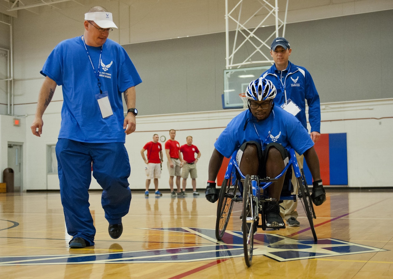 Air Force Tech. Sgt. Ryan Delaney, left, a wounded warrior mentor, watches Tremayne Maxwell, an Air Force wounded warrior athlete, perfect his wheelchair basketball rolling skills during the first day of an introductory adaptive sports and rehabilitation camp at Eglin Air Force Base, Fla., April 13, 2015. Delaney, a flight chief with the 412th Security Forces Squadron at Edwards Air Force Base, Calif., helped prepare approximately 45 participants in the week-long camp and training events. U.S. Air Force photo by Samuel King Jr.