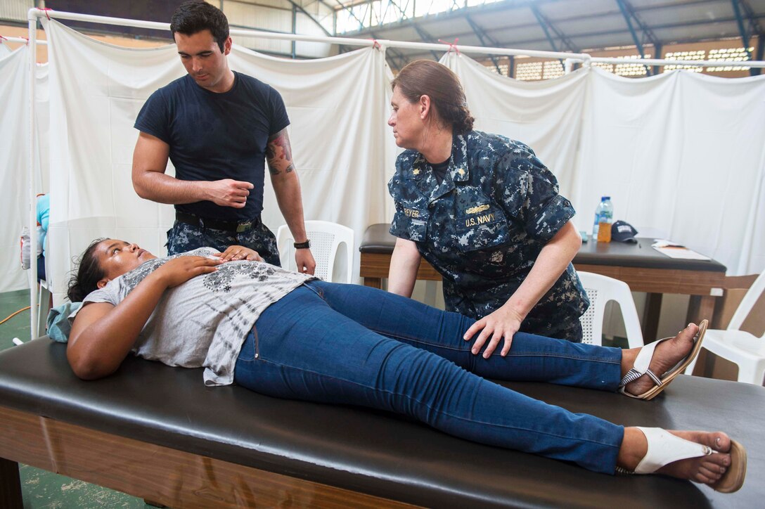 U.S. Navy Seaman Osvaldo Castro, left, translates for a patient during a physical therapy consultation with U.S. Navy Lt. Cmdr. Carrie Dreyer, a physical therapist assigned to Walter Reed National Military Medical Center in Bethesda Md., at a medical treatment site set up in a sports complex during Continuing Promise 2015 in Puerto Barrios, Guatemala, April 24, 2015. Castro is a hospitalman.