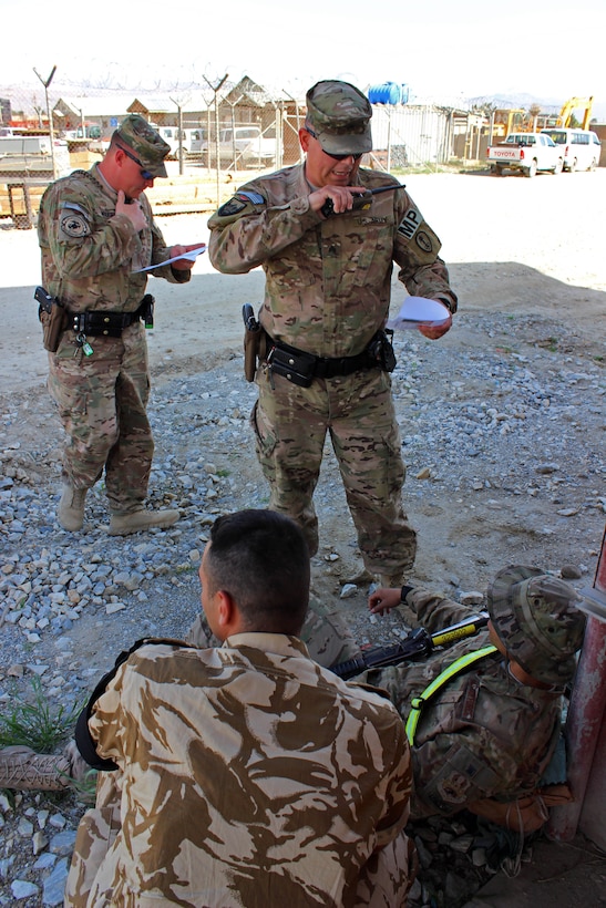U.S. Army Sgt. Dubrul, center, calls in 9 Line MEDEVAC report after providing medical aid to a mock casualty during a base defense emergency response exercise on Bagram Airfield, Afghanistan, April 10, 2015.