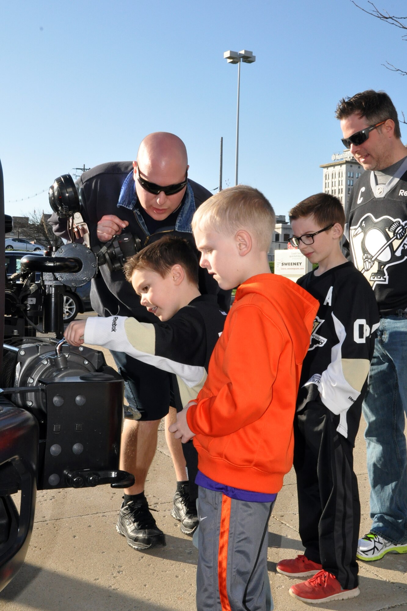 Firefighter Christopher Kail, assigned to the Air Force Reserve’s 910th Civil Engineer Fire Department, explains the winch on the front of a firefighting vehicle to a group of fans outside the Covelli Centre during pre-game festivities for a Youngstown Phantoms hockey game here, April 11, 2015. A group of Citizen Airmen, based at nearby Youngstown Air Reserve Station, Ohio, participated in YARS Night Out activities before and during the game including a static display of 910th CEF vehicles. Prior to the game, the Phantoms, a member of the United States Hockey League, were presented the league’s Anderson Trophy for achieving the most points by a team this season. The Phantoms defeated Team USA 7-1 to complete their regular season in front of a home ice crowd of more than 4000 fans. (U.S. Air Force photo/ Master Sgt. Bob Barko Jr.)