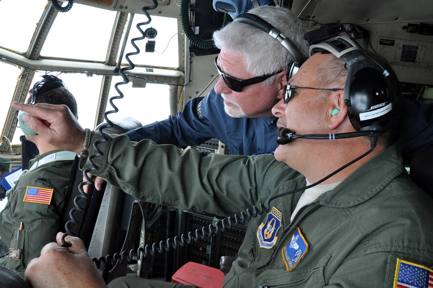 Air Force Reserve Master Sgt. Vincent Bartlomain (right), an evaluator flight engineer assigned to the 757th Airlift Squadron, points out the flight deck windows of an Air Force Reserve C-130H Hercules tactical cargo aircraft, assigned to the 910th Airlift Wing based at Youngstown Air Reserve Station (YARS), Ohio, as James Woofter (center), owner of the Cortland News, looks on during a flight to Keesler Air Force Base, Mississippi, April 15, 2015. Woofter was one of 31 Mahoning Valley civic leaders participating in the 910th Airlift Wing’s Civic Leader Tour, held April 15-16, 2015. The group of civic leaders and their military escorts, attended the two-day, one-night event, designed to give them a better understanding of the Air Force Reserve mission and how it differs from base to base around the country. (U.S. Air Force photo/Master Sgt. Bob Barko Jr.)