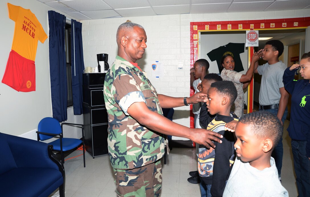 Randolph Scott, Capability Assessment Support Center project administrator, Marine Corps Systems Command, Albany, Ga., instructs Albany Young Marine recruits on proper hand salutes during their boot camp at Marine Corps Logistics Base Albany, April 25. The Albany Young Marine recruits are participating in a 26-hour boot camp that began April 18 and will graduate May 16.