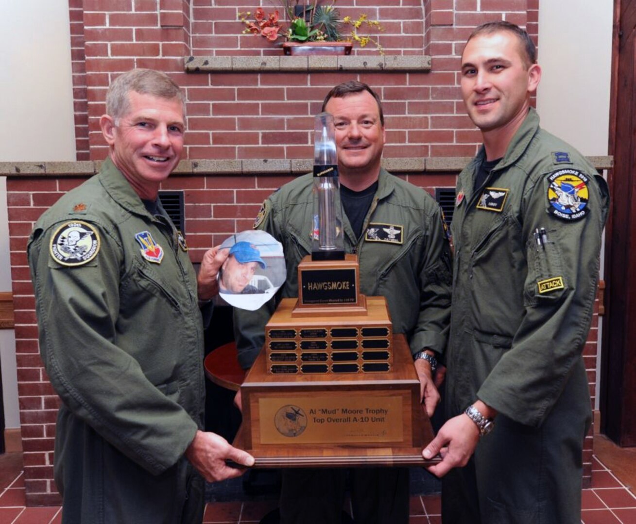 Members of the Idaho Air National Guard’s 190th Fighter Squadron from left to right, Maj. Scott Downey, Lt. Col. Ryan Odneal and Capt. Ryan Brown pose with the trophy that they won during Hawgsmoke 2010 at Gowen Air National Guard Base in Boise, Idaho, Oct. 16, 2010. Missing from the photo, but pictured in a photo cutout, is Maj. Justin Keskey.