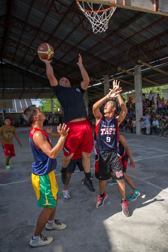 U.S. Navy Steelworker 2nd Class Juan Lopez, assigned to Naval Mobile Construction Battalion 5, shoots a layup at a friendly basketball game between Barangay Taft basketball players and players from the Combined-Joint Civil-Military Operations Task Force on the island of Panay in Tapaz, Philippines, during Balikatan 2015, April 28. The goodwill game was held for some fun and entertainment following the conclusion of the combined U.S. and AFP force’s humanitarian and disaster response activities on the island. Balikatan, which means “shoulder to shoulder” in Filipino, is an annual bilateral training exercise aimed at improving the ability of Philippine and U.S. military forces to work together during planning, humanitarian assistance and disaster relief operations.