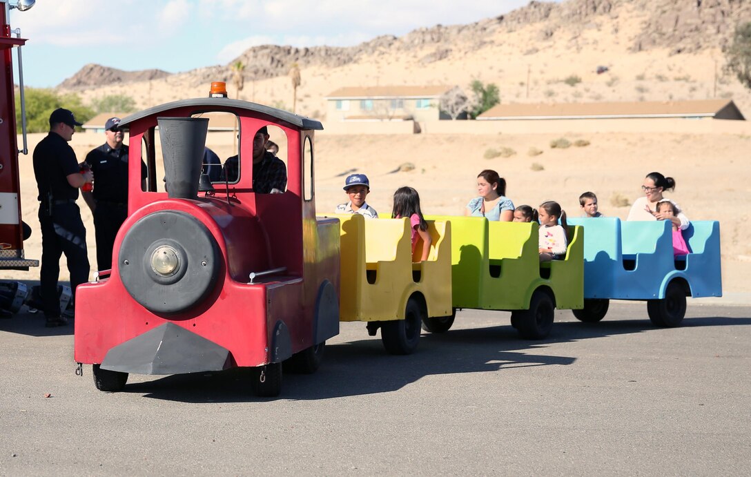 Combat Center families enjoy a ride on a miniature train through Lincoln Military Housing Athletic Field parking lot during the Earth Day Extravaganza, April 24, 2015. The event also provided a live performance from local band Desert Soul. (Official Marine Corps by Lance Cpl. Thomas Mudd/ Released)