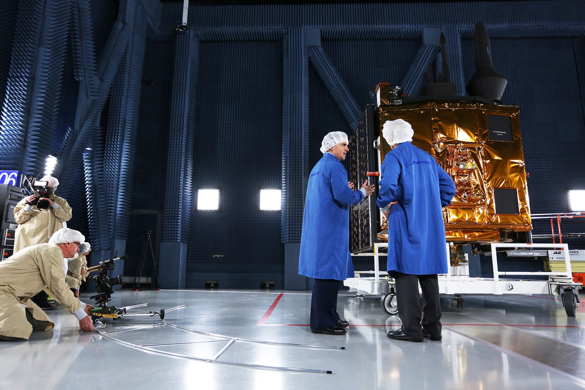 CBS/60 Minutes correspondent Dave Martin interviews Brig. Gen. Bill Cooley (standing-left), director of the GPS directorate for the Space and Missile Systems Center, in front of a GPS-IIF satellite at the Boeing facility in El Segundo, California for a two-part segment on Air Force Space Command that aired April 26, 2015. (Photo by Maj Eric Simon)