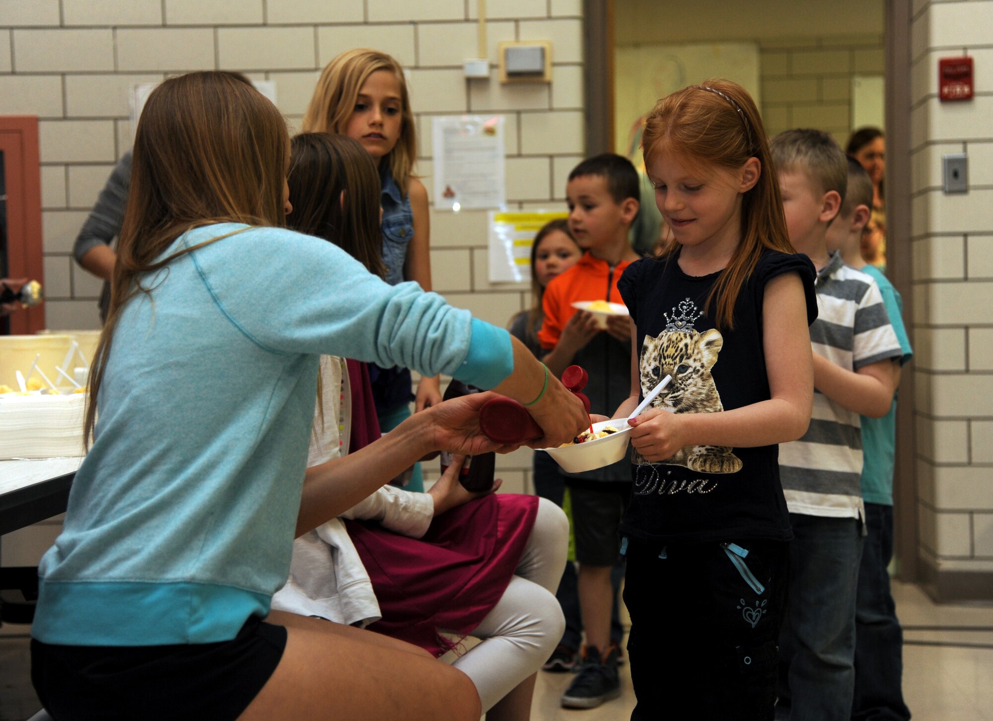 Students from Nathan Twining Elementary/Middle School on Grand Forks Air Force Base, N.D. attend an ice cream social on April 29, 2015 as part of the Month of the Military Child. The social was organized by members of the Student Council who volunteer their time to make events like this possible, while juggling schoolwork at the same time. The ice cream was paid for by the Parent Teacher Organization at Twining. (U.S. Air Force photo by Senior Airman Zachiah Roberson/released)