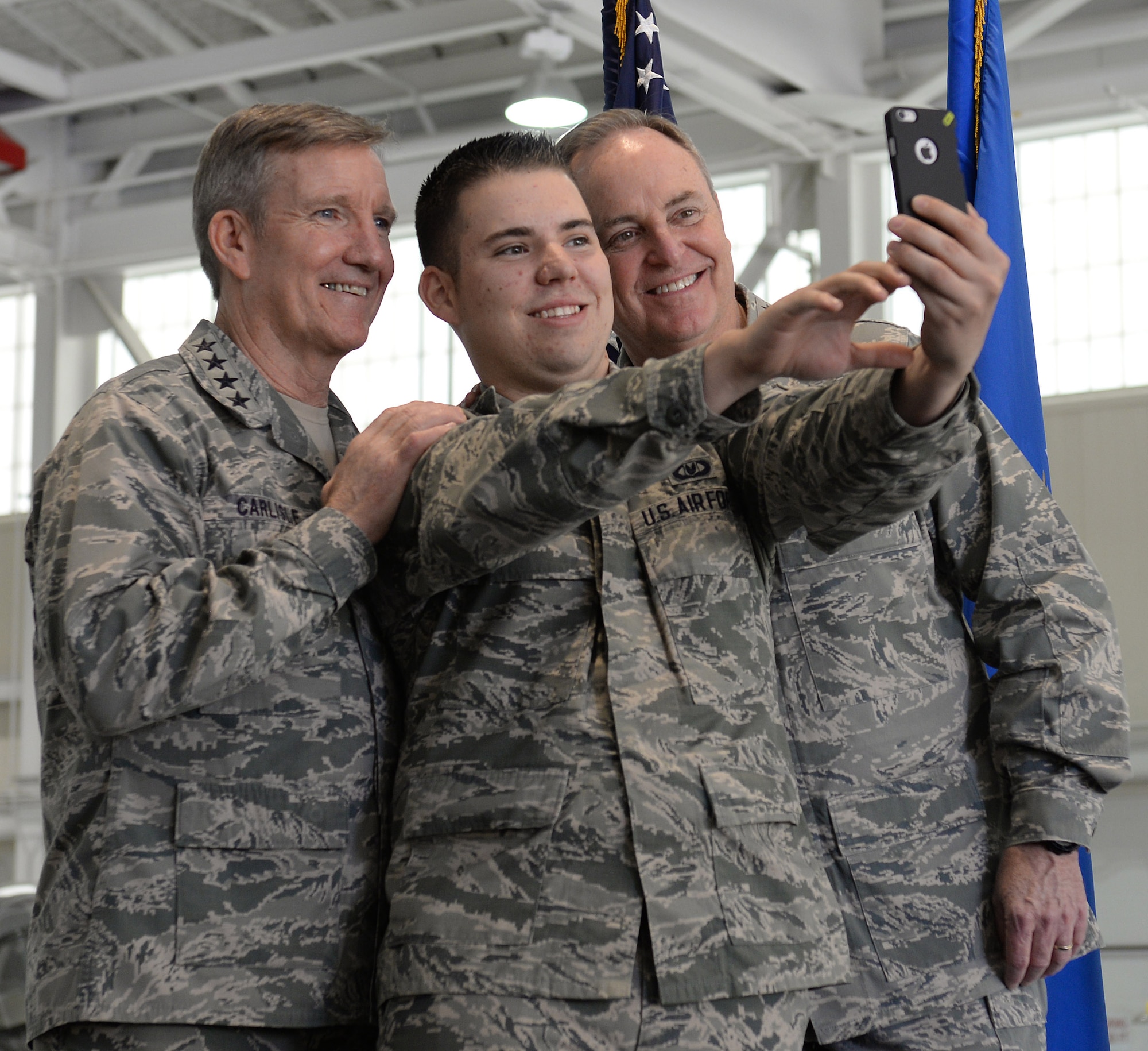 U.S. Air Force Gen. Hawk Carlisle, commander of Air Combat Command, left, and U.S. Air Force Chief of Staff Gen. Mark A. Welsh III, far right, take a photo with Airman 1st Class Justin Shuttleworth, 1st Operations Squadron aircrew flight equipment apprentice, after an all call at Langley Air Force Base, Va., April 28, 2015. Welsh and his wife Betty spent three days touring Langley and learning about key issues that affect today’s Airmen and their families. (U.S. Air Force photo by Staff Sgt. Teresa J. Cleveland/Released)