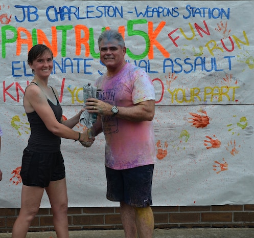 Captain Timothy Sparks, Joint Base Charleston deputy commander congratulates Lt. JG Jennifer Oblinger of Naval Nuclear Power Training Command who came in first place for the women at the Paint Run 5K  Fun Run April 25, 2015 at Joint Base Charleston - Weapons Station, S.C. Oblinger finished with a time of 20:34 for the top female runner.  This free event was open to everyone and was co-hosted by Joint Base Charleston Sexual Assault Prevention and Response Program. April is sexual assault awareness month. This year’s theme is, “Eliminate Sexual Assault: Know your part. Do your part.” The purpose of sexual assault awareness month is to raise awareness about sexual assault prevention and support sexual assault survivors. (Courtesy Photo / Jessica Donnelly) 
