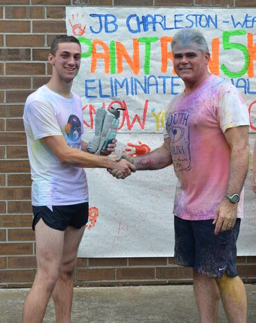 Captain Timothy Sparks, Joint Base Charleston deputy commander congratulates MM3 Dillon Oergel who came in first place at the Paint Run 5K  Fun Run April 25, 2015 at Joint Base Charleston - Weapons Station, S.C., Oergel finished with a time of 19:00 for the top male runner.  This free event was open to everyone and was co-hosted by Joint Base Charleston Sexual Assault Prevention and Response Program. April is sexual assault awareness month. This year’s theme is, “Eliminate Sexual Assault: Know your part. Do your part.” The purpose of sexual assault awareness month is to raise awareness about sexual assault prevention and support sexual assault survivors. (Courtesy Photo / Jessica Donnelly) 
