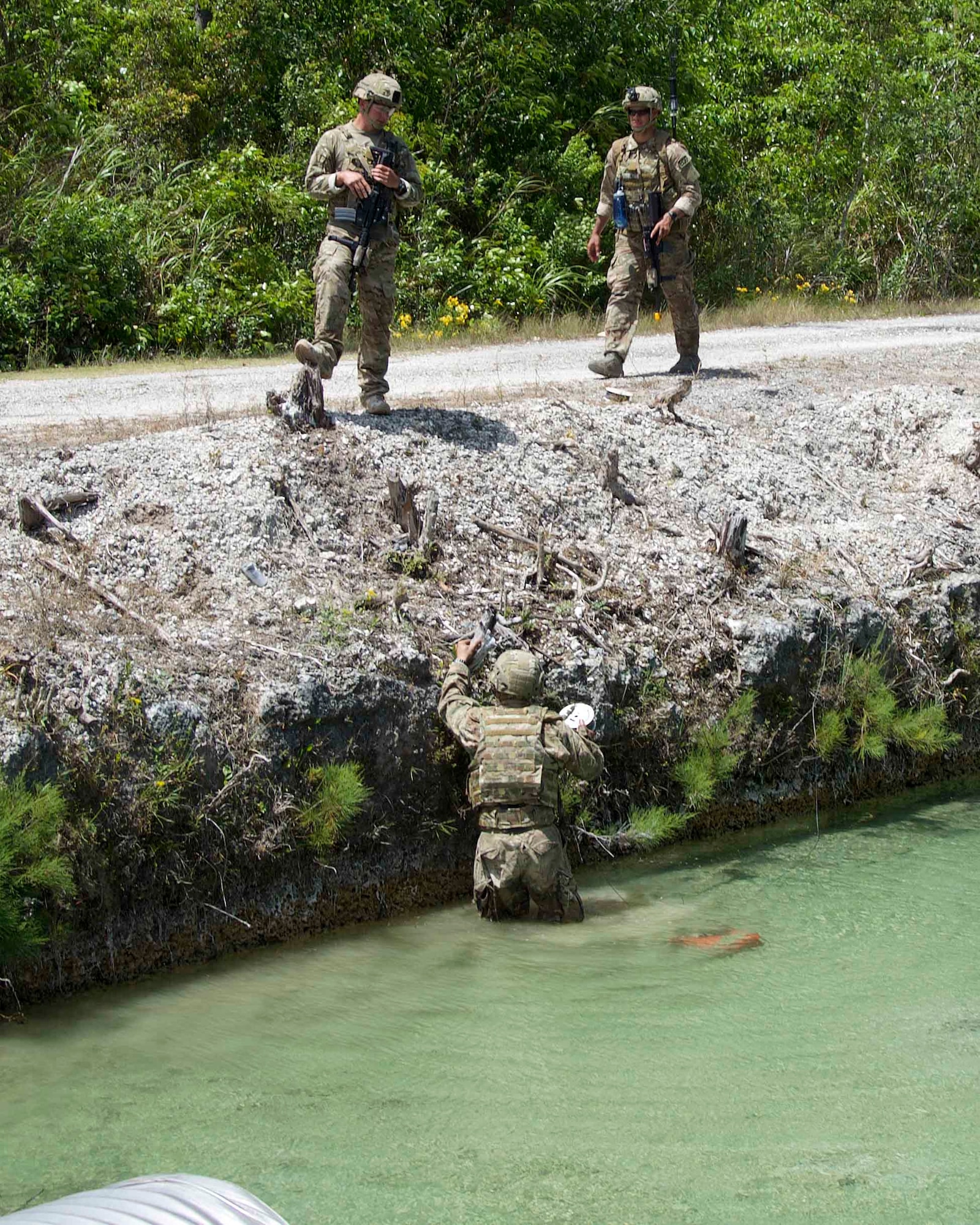 Staff Sgt. Richel Castillo, Staff Sgt. Miguel Hill team members and Tech. Sgt. Aaron Johns, team leader, from the 482nd Civil Engineering Squadron Explosive Ordnance Disposal Flight, build and place a charge on an improvised explosive device in the water at Homestead Air Reserve Base, Fla., April 7. The EOD Flight conducted dismounted counter-IED operations as part of a weeklong training exercise aimed to prepare the reservists for combat operations. (U.S. Air Force photo by Staff Sgt. Jaimi L. Upthegrove)
