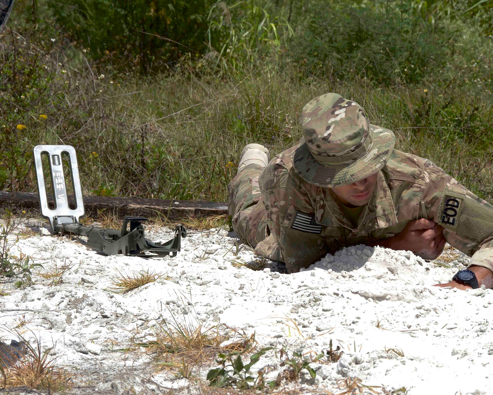 Staff Sgt. Miguel Hill, 482nd Civil Engineering Squadron Explosive Ordnance Disposal Flight team member, uses his hand to uncover an improvised explosive device buried in the sand that he located with a compact metal detector at Homestead Air Reserve Base, Fla., April 6. This was part of a weeklong training exercise created to prepare members of the team for deployments by giving Reserve Airmen firsthand experience dealing with IEDs when robotic means aren't feasible. (U.S. Air Force photo by Staff Sgt. Jaimi L. Upthegrove)