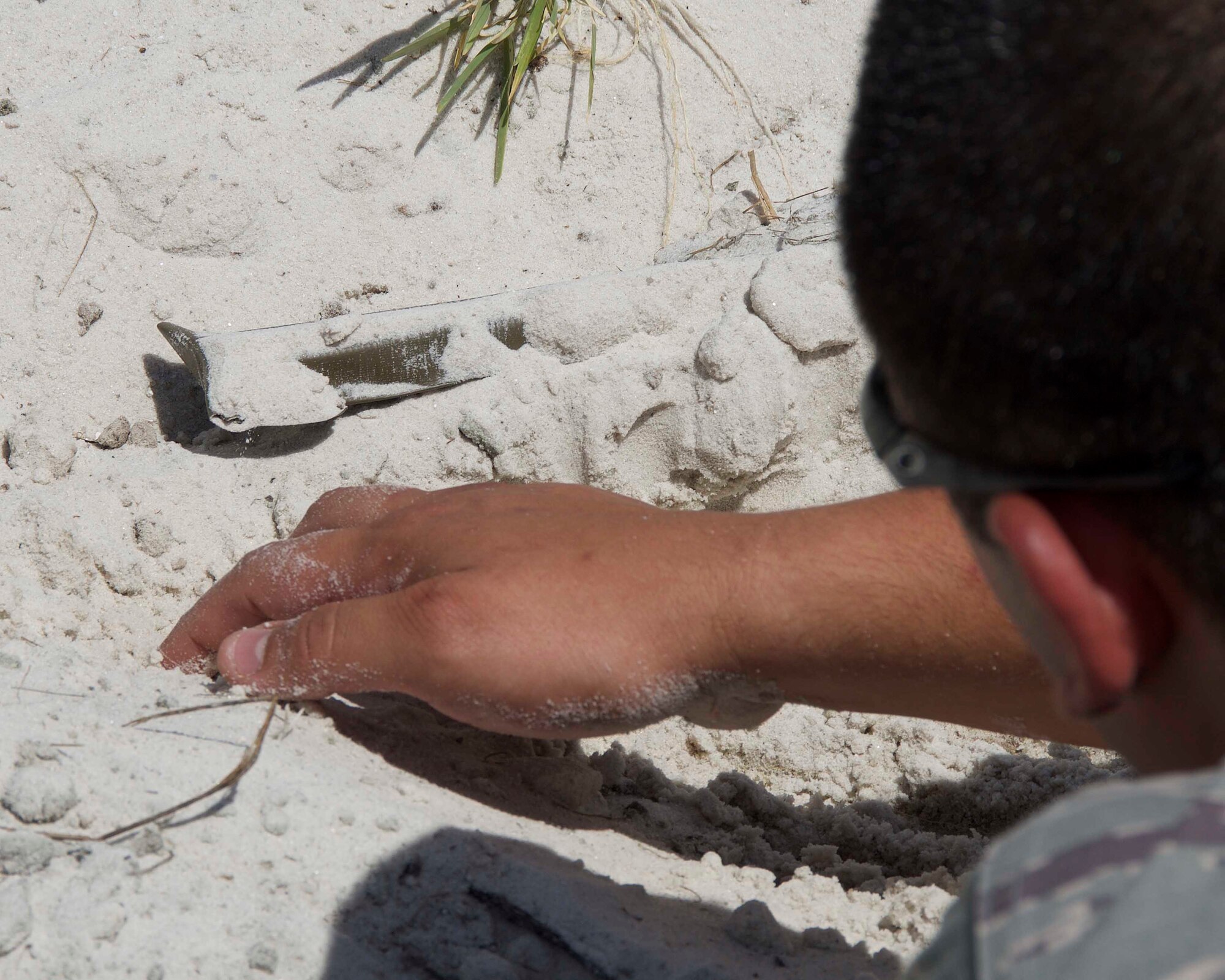 Staff Sgt. Fernando Olivas Fortin, 482nd Civil Engineering Squadron Explosive Ordnance Disposal Flight team member, carefully uncovers an improvised explosive device to get an idea of how it’s set up so he can make a plan to safely dispose of it at Homestead Air Reserve Base, Fla., April 6. The EOD Flight conducted dismounted counter-IED operations as part of a weeklong training exercise aimed to prepare the reservists for combat operations. (U.S. Air Force photo by Staff Sgt. Jaimi L. Upthegrove)