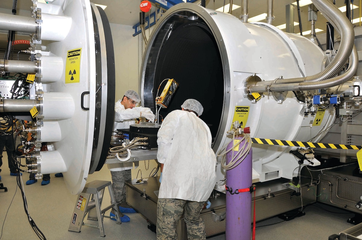 Members of AEDC’s Space Threat Assessment Testbed (STAT) Test & Evaluation team install a microsatellite in the STAT chamber before conducting a test. (Photo by Jacqueline Cowan)