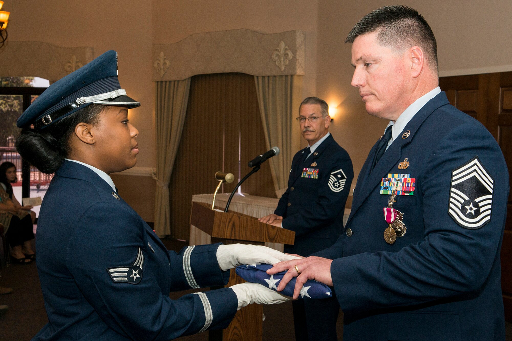 U.S. Air Force Chief Master Sgt. Mark Traynham is presented with an American Flag during his retirement ceremony on April 25, 2015, Barksdale Air Force Base, La. Traynham is the Security Forces Manager assigned to the 307th Security Forces Squadron and is retiring from the Air Force Reserve after 33 years of service. (U.S. Air Force photo by Master Sgt. Greg Steele/Released)