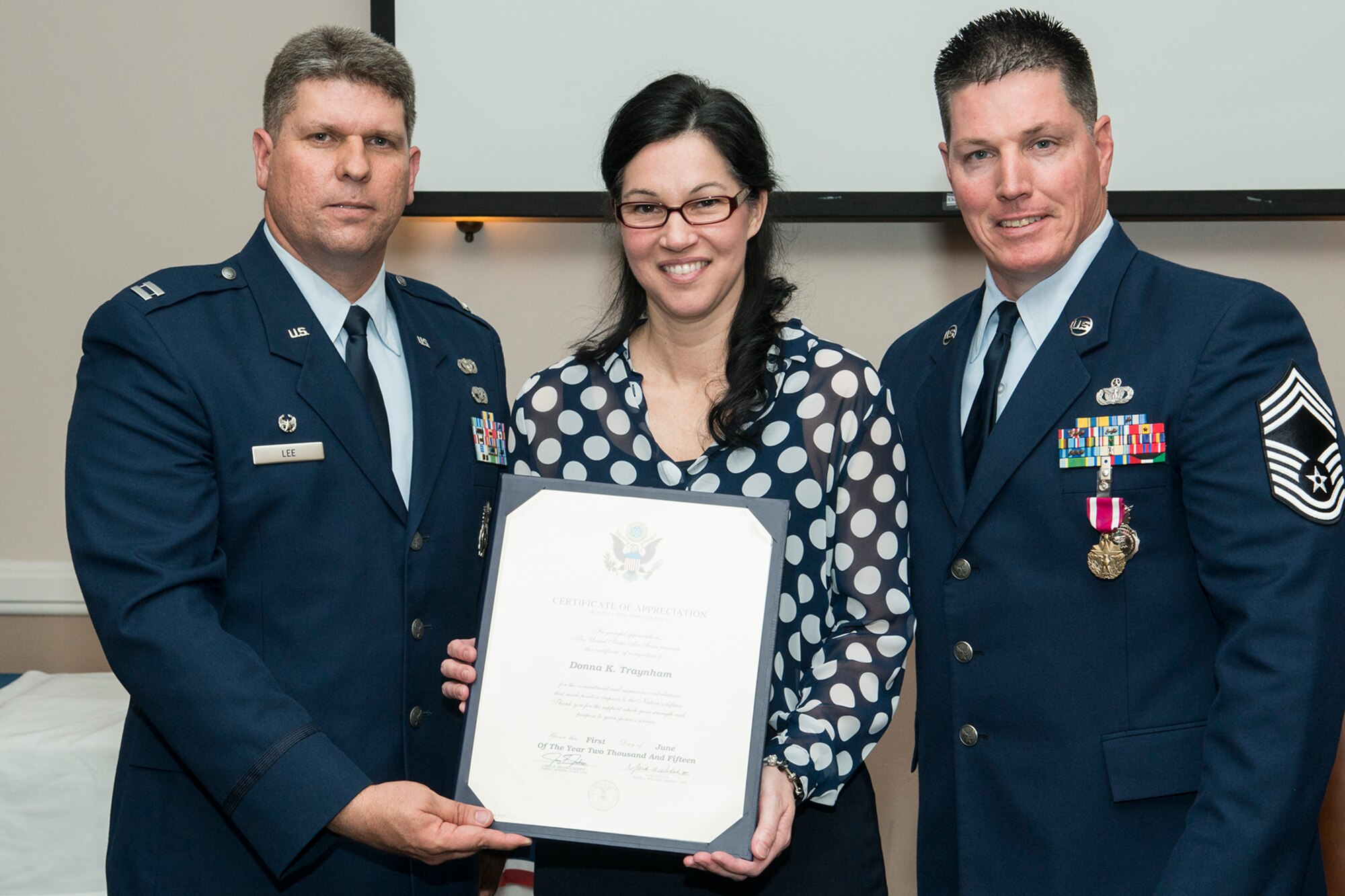 Donna Traynham is presented a Certificate of Appreciation during a retirement ceremony for her husband, U.S. Air Force Chief Master Sgt. Mark Traynham, on April 25, 2015, Barksdale Air Force Base, La. Traynham is the Security Forces Manager assigned to the 307th Security Forces Squadron and is retiring from the Air Force Reserve after 33 years of service. (U.S. Air Force photo by Master Sgt. Greg Steele/Released)