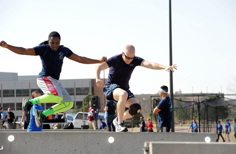 Schriever personnel jump over barriers during the Sexual Assault Awareness and Prevention Month Inflatable 5K run April 23, 2015, at Schriever Air Force Base, Colo. The run was hosted to raise awareness about sexual assault. (U.S. Air Force photo/Katie Calver)