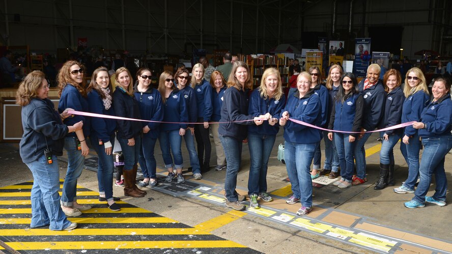 Members of the Mildenhall Spouses’ Club cut the ribbon announcing the opening of the 45th annual Mayfair Bazaar April 24, 2015, on RAF Mildenhall, England. Vendors from the United Kingdom and Europe had stands offering a variety of items for sale that included crafts, antiques, books, cheese and other unique items. (U.S. Air Force photo by Karen Abeyasekere/Released)
