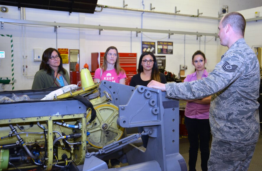 U.S. Air Force Tech. Sgt. Eric Vangsness, right, 100th Maintenance Group Hydraulics backshop section chief from Decorah, Iowa, explains the mission of his shop to spouses from the 100th MXG during a spouses’ appreciation day event April 24, 2015, on RAF Mildenhall, England. Spouses spent the day visiting workcenters gaining insight into what their military spouses do and how they contribute to RAF Mildenhall’s mission. (U.S. Air Force photo by Karen Abeyasekere/Released)