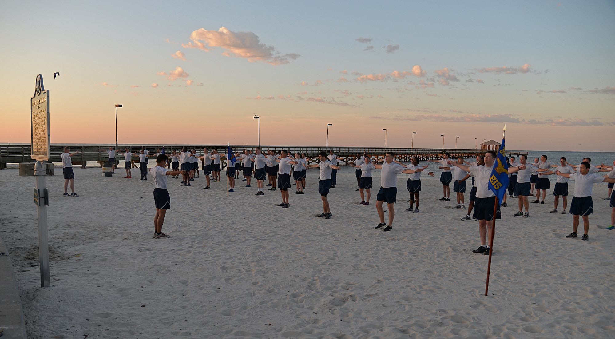Members of Team Keesler warm up before a physical training event at the beach, April 22, 2015, Biloxi, Miss.  The 85th Engineering Installation Squadron invited other Keesler members to join the 90-minute PT session consisting of a 1.5 mile run and different stations for aerobic exercises. (U.S. Air Force photo by Senior Airman Holly Mansfield)