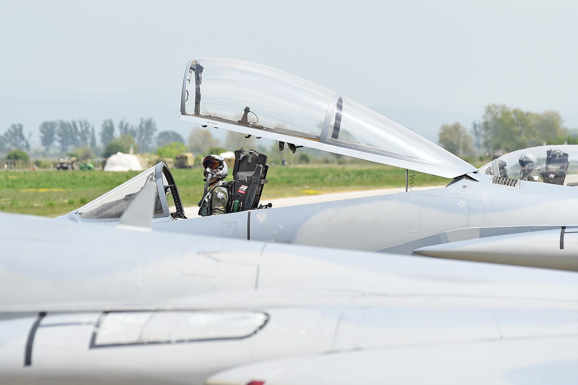 An F-15 Eagle pilot from the 159th Fighter Wing, Louisiana Air National Guard watches a Bulgarian MiG-29 takeoff prior to startup for a training mission at Graf Ignatievo Air Base, near Plovdiv, Bulgaria, April 28, 2015. The joint mission is designed to demonstrate the shared commitment and close cooperation with Bulgaria and all NATO allies on countering a range of regional and global threats. (U.S. Air National Guard photo by Master Sgt. Toby M. Valadie, 159th Public Affairs Office/Released)