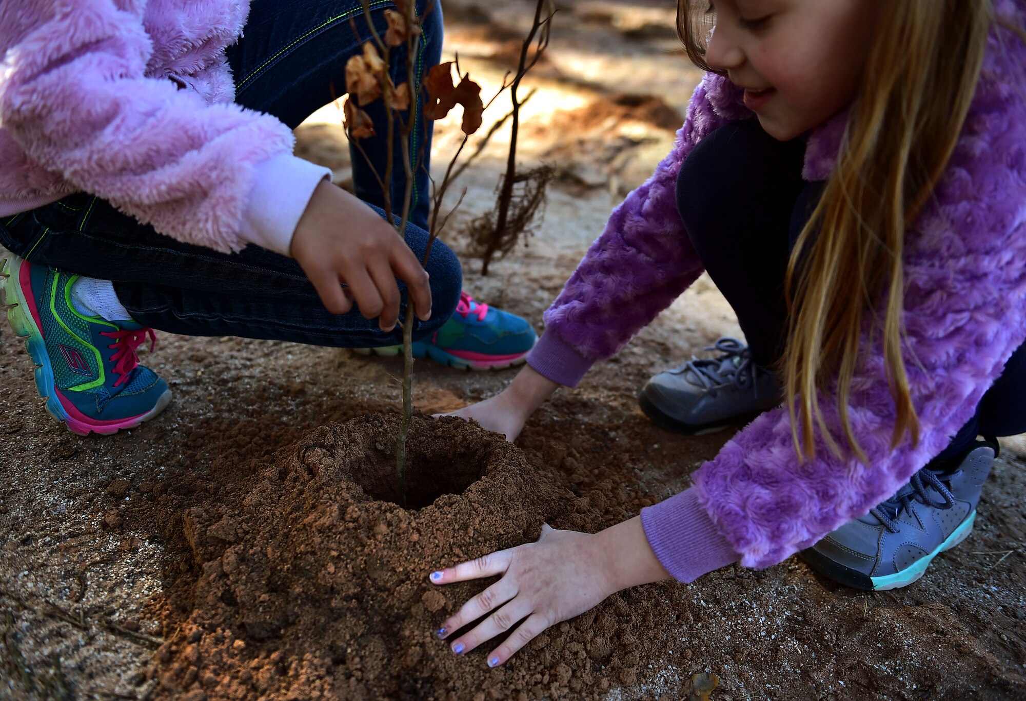 Jordyn Blosser and her friend, second-grade students from Ramstein Elementary School, plant a tree together in honor of Earth Day April 22, 2015, at Ramstein Air Base, Germany. Blosser and her classmates were paired in teams and worked together to plant more than 100 trees on Ramstein as part of Earth Day 2015. The class also worked with the Boy and Girl Scouts of the United States of America to clean road borders leading to Ramstein. (U.S. Air Force photo/Staff Sgt. Sara Keller)