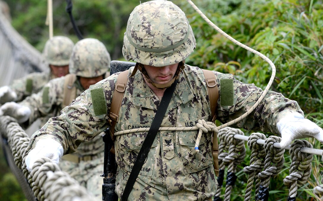 U.S. Navy Seaman Andrew Cahoon crosses a three-strand bridge on the Jungle Warfare Training Center in Okinawa, Japan, April 24, 2015. 