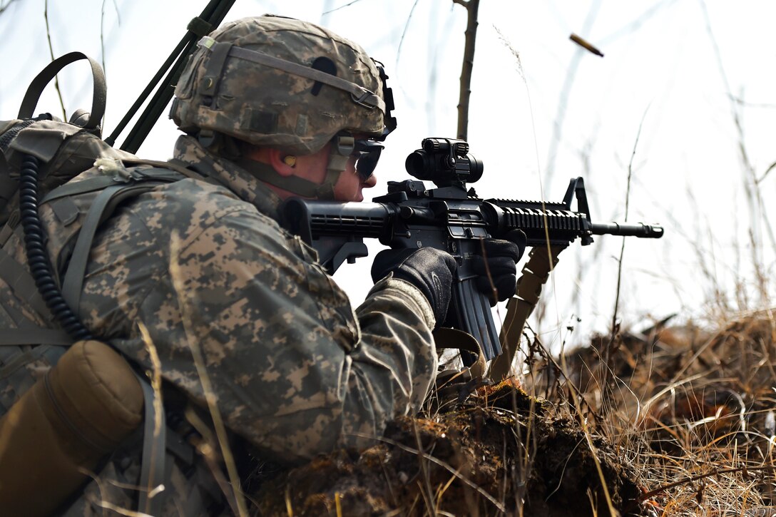 An Army paratrooper shoots at a simulated enemy position during a heavy weapons live-fire exercise on Joint Base Elmendorf-Richardson, Alaska, April 24, 2015.