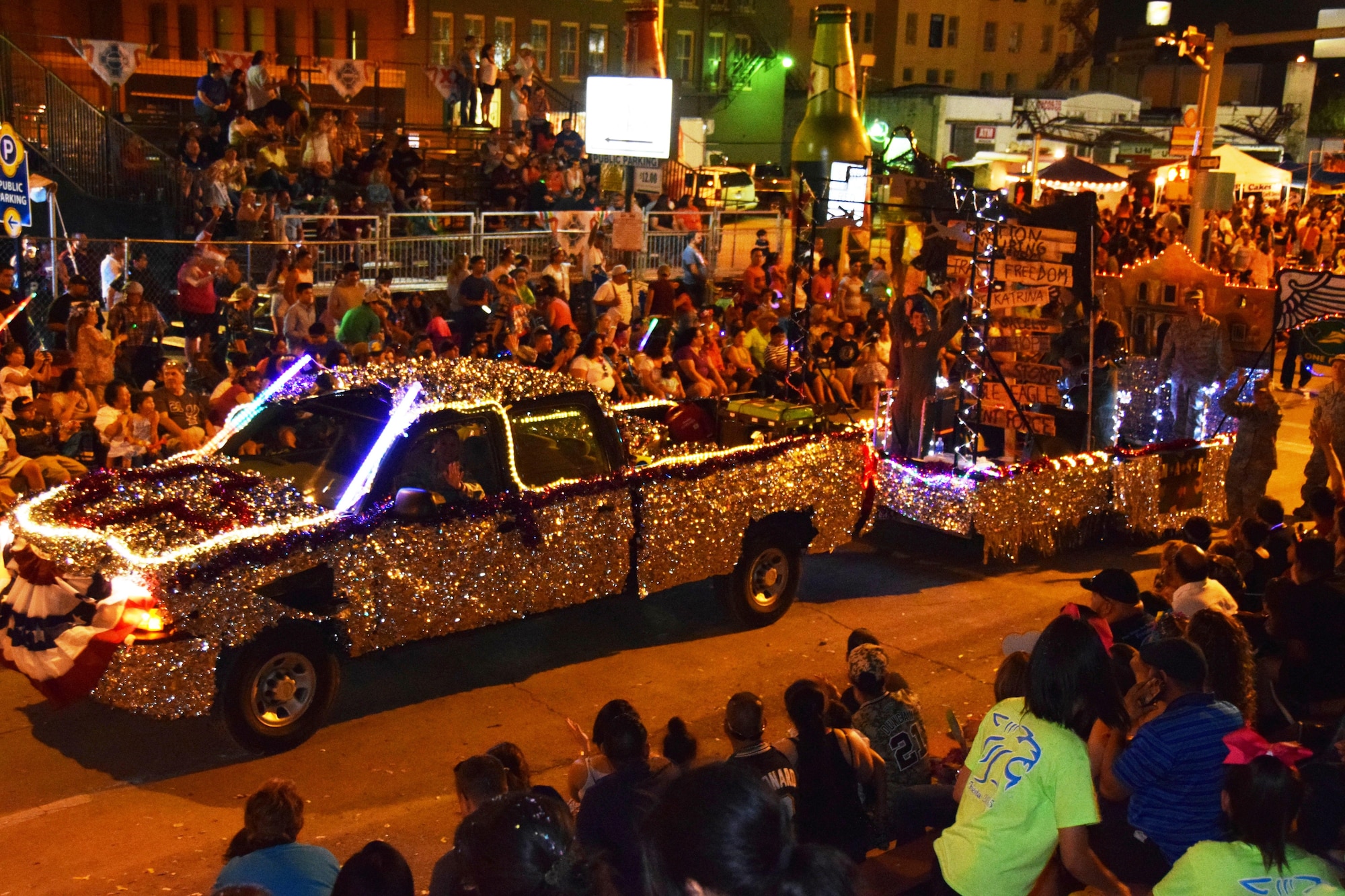 The 433rd Airlift Wing's "M*A*S*H” themed float moves through downtown San Antonio during the Fiesta Flambeau Parade, April 25, 2015. The parade's theme was “Television: Then and Now,” and according to the Fiesta San Antonio program is “America’s largest illuminated night parade.” Over 600,000 spectators lined the streets of San Antonio on a humid spring evening to see over 200 floats and marching bands perform in the grand finale of Fiesta Week. It is estimated 750,000 viewers (television and internet) watched this year's parade. (U.S. Air Force Photo/ Tech. Sgt. Carlos J. Trevino)
