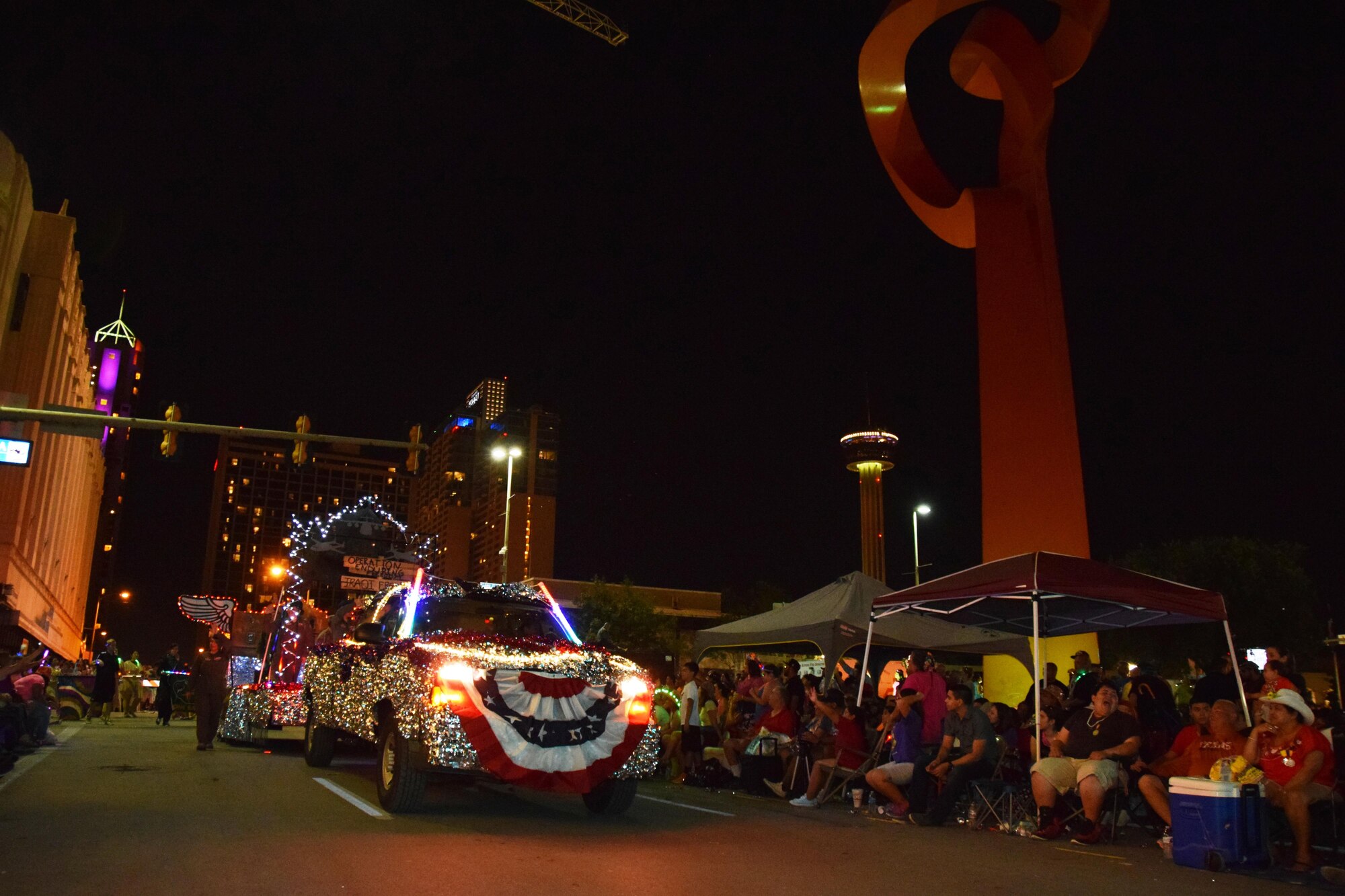 The float representing the 433rd "Alamo Wing" at the Flambeau Parade in San Antonio, April 25, 2015 turns on W. Commerce Street passing by the cities landmark sculpture, “The Torch of Friendship” during the Fiesta Flambeau Parade. Over 600,000 spectators lined the streets of San Antonio on a humid spring evening to see over 200 floats and marching bands perform in the grand finale of Fiesta Week. 
