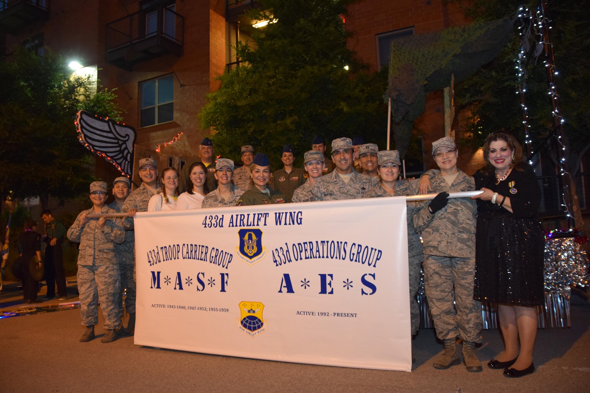 The 433rd Airlift Wing's parade float and participants prior to hitting the streets of San Antonio during the Fiesta Flambeau Parade, April 25, 2015. Over 600,000 spectators lined the streets of San Antonio on a humid spring evening to see over 200 floats and marching bands perform in the grand finale of Fiesta Week. The parade's theme was “Television: Then and Now," and according to the Fiesta San Antonio program, is “America’s largest illuminated night parade.” It is estimated, 750,000 viewers (television and internet) watched this year's parade. (U.S. Air Force Photo/ Tech. Sgt. Carlos J. Trevino)
