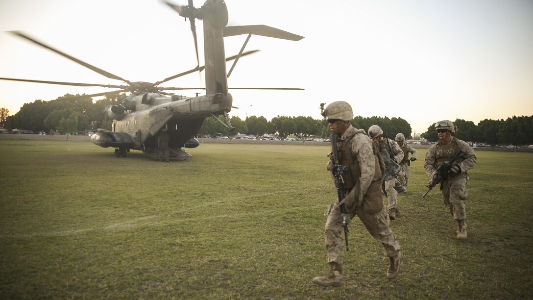 Marines and sailors with 1st Battalion, 5th Marine Regiment, exit a CH-53E Super Stallion helicopter after completing a casualty evacuation drill during a foreign humanitarian assistance exercise at Kiwanis Park, Yuma, Arizona, as part of Weapons and Tactics Instructor Course 2-15, April 17. The exercise included multiple helicopter insertions using the CH-53E Super Stallion and UH-1Y Venom to replenish supplies, transport Marines, and provide evacuation for role-players with notional critical injuries. (Official Marine Corps Photo by Cpl. Charles Santamaria/Released)