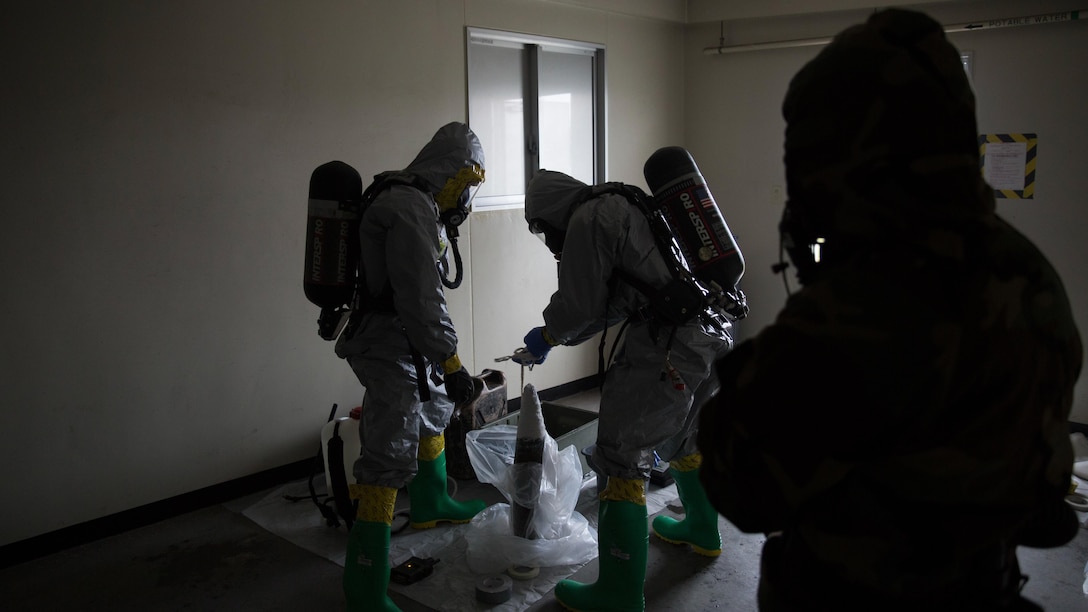 Marines contain a leaking ordnance round during leak, seal, package and decontamination training April 21 at the gas chamber on Camp Hansen, Okinawa. Explosive ordnance disposal technicians and chemical, biological, radiological, nuclear defense specialists placed a leaking ordnance package in the gas chamber, using chlorobenzylidene malonitrile, also known as tear gas, to simulate the emission of harmful gases.  The EOD technicians and CBRN defense specialists used protective equipment to safely contain the leaking ordnance and prepare the package for transport out of the affected area before completing the decontamination process. The training instilled the Marines’ confidence in the safety equipment and procedures used to mitigate CBRN-related hazards. The Marines are with 9th Engineer Support Battalion and Marine Logistics Group Headquarters Regiment, 3rd MLG, III Marine Expeditionary Force.