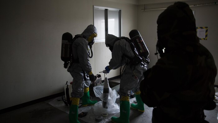 Marines contain a leaking ordnance round during leak, seal, package and decontamination training April 21 at the gas chamber on Camp Hansen, Okinawa. Explosive ordnance disposal technicians and chemical, biological, radiological, nuclear defense specialists placed a leaking ordnance package in the gas chamber, using chlorobenzylidene malonitrile, also known as tear gas, to simulate the emission of harmful gases.  The EOD technicians and CBRN defense specialists used protective equipment to safely contain the leaking ordnance and prepare the package for transport out of the affected area before completing the decontamination process. The training instilled the Marines’ confidence in the safety equipment and procedures used to mitigate CBRN-related hazards. The Marines are with 9th Engineer Support Battalion and Marine Logistics Group Headquarters Regiment, 3rd MLG, III Marine Expeditionary Force.