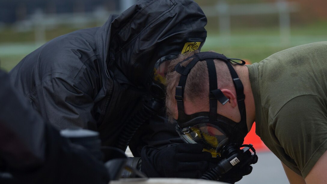 A chemical, biological, radiological, nuclear defense specialist assists a Marine in removing his gas mask after leak, seal, package and decontamination training April 21 at the gas chamber on Camp Hansen, Okinawa. Explosive ordnance disposal technicians and chemical, biological, radiological, nuclear defense specialists placed a leaking ordnance package in the gas chamber, using chlorobenzylidene malonitrile, also known as tear gas, to simulate the emission of harmful gases.  The EOD technicians and CBRN defense specialists used protective equipment to perform general decontamination of the affected area and prepare the leaking ordnance for safe containment and transport before completing the decontamination process. The training instilled the Marines’ confidence in the safety equipment and procedures used to mitigate CBRN-related hazards. The Marines are with 9th Engineer Support Battalion and Marine Logistics Group Headquarters Regiment, 3rd MLG, III Marine Expeditionary Force.