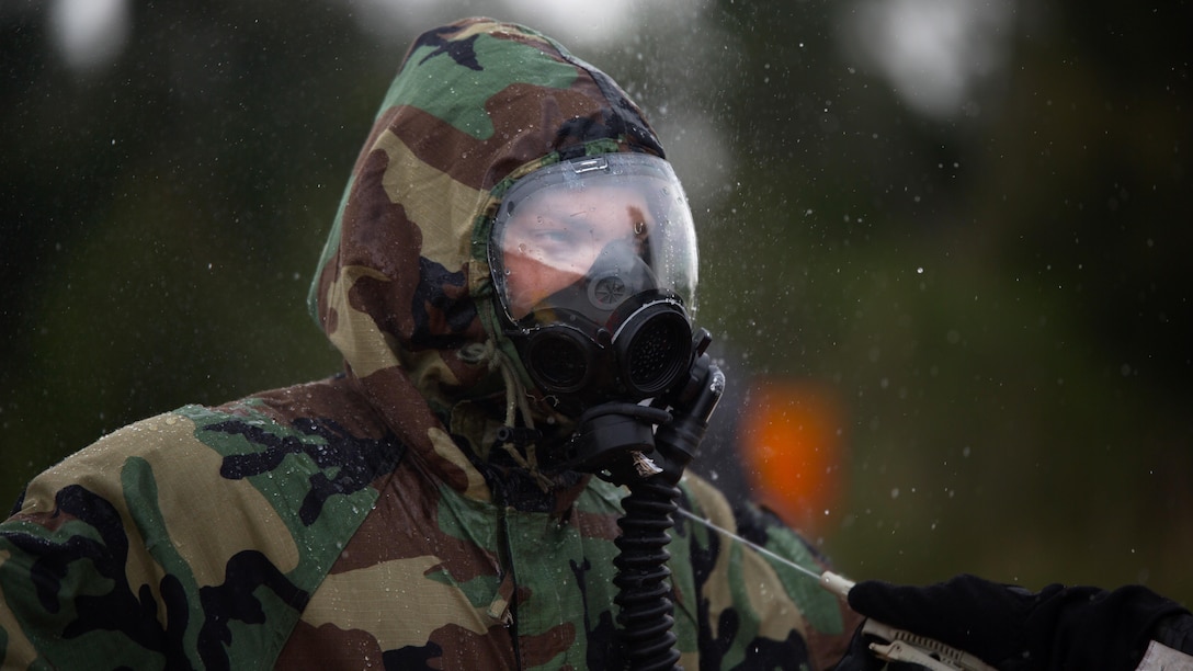 An explosive ordnance disposal technician undergoes the decontamination process after leak, seal, package and decontamination training April 21 at the gas chamber on Camp Hansen, Okinawa. Explosive ordnance disposal technicians and chemical, biological, radiological, nuclear defense specialists placed a leaking ordnance package in the gas chamber, using chlorobenzylidene malonitrile, also known as tear gas, to simulate the emission of harmful gases.  The EOD technicians and CBRN defense specialists used protective equipment to perform general decontamination of the affected area and prepare the leaking ordnance for safe containment and transport before completing the decontamination process. The training instilled the Marines’ confidence in their safety equipment and procedures used to mitigate CBRN-related hazards. The Marines are with 9th Engineer Support Battalion and Marine Logistics Group Headquarters Regiment, 3rd MLG, III Marine Expeditionary Force.