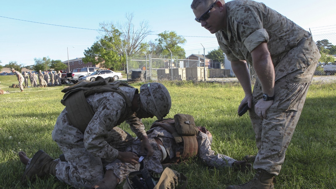 Pfc. Kevin J. Oronaponce, a rifleman with 2nd Battalion, 2nd Marine Regiment, applies a tourniquet to a mannequin during the final test for the Combat Trauma Care Course aboard Marine Corps Base Camp Lejeune, North Carolina, April 24, 2015. The mannequins were equipped with a system that allows artificial blood to bleed from various wounds and recorded voices to talk, providing a more realistic experience. (U.S. Marine Corps photo by Pfc. David N. Hersey/Released)