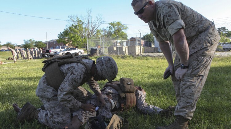 Pfc. Kevin J. Oronaponce, a rifleman with 2nd Battalion, 2nd Marine Regiment, applies a tourniquet to a mannequin during the final test for the Combat Trauma Care Course aboard Marine Corps Base Camp Lejeune, North Carolina, April 24, 2015. The mannequins were equipped with a system that allows artificial blood to bleed from various wounds and recorded voices to talk, providing a more realistic experience. (U.S. Marine Corps photo by Pfc. David N. Hersey/Released)