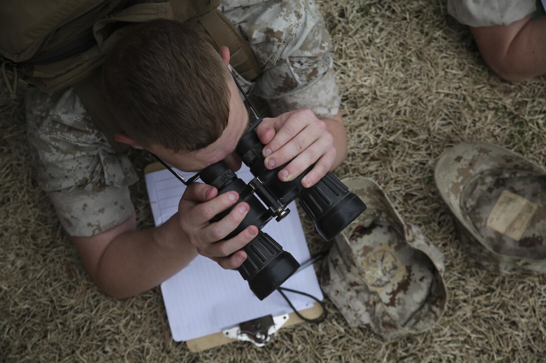 A Marine with II Marine Expeditionary Force locates practice targets using binoculars while conducting observation lane training at the Division Combat Skills Center aboard Camp Lejeune, N.C., March 9, 2015, during a designated marksmanship course. Marines use binoculars during observation lane training as part of the designated marksmanship course to aid in finding targets that are at a great distance. Observation lane training aids Marines when they later deploy to combat environments where they may encounter threats at variable distances.