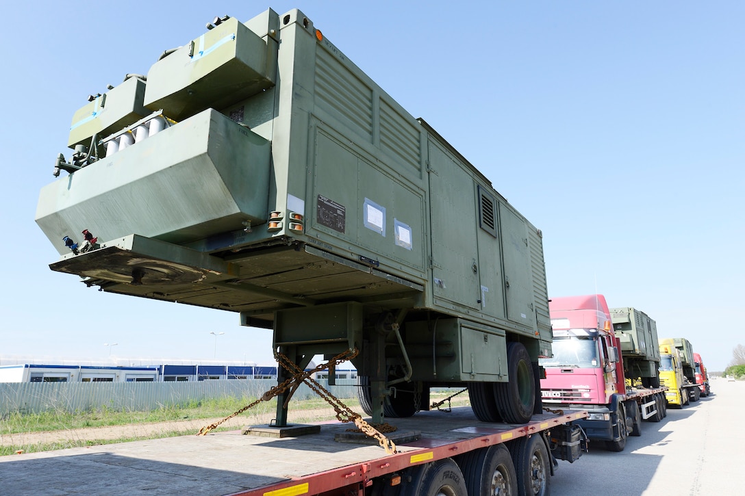 A line of trucks carrying portable generators awaits installation at Naval Support Facility Deveselu, Romania. U.S. Army Corps of Engineers 249th Engineer Battalion transported the generators from Fort Belvoir, Virginia. The Corps later installed four portable generators to produce 3.2 megawatts of electrical power for the Aegis Ashore facility, helping it become operational.