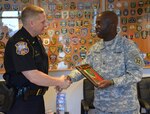 Adjutant General of Florida Maj. Gen. Michael Calhoun presents a plaque on behalf of the Guyana Defence Force to St. Augustine Beach Police Chief Robert Hardwick on April 30, 2015, in St. Augustine Beach, Florida. The Florida National Guard's State Partnership Program (SPP) helped facilitate the transfer of more than $1 million in radio equipment between two Florida Law enforcement agencies and the Guyana Defense Force in South America. 